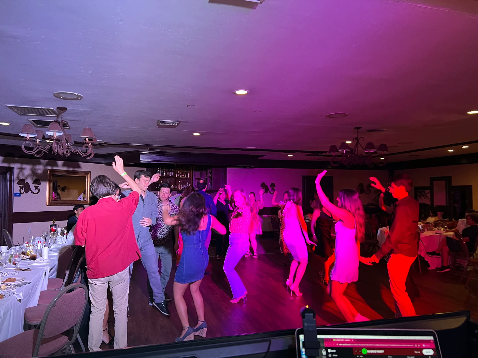 Full dance floor under pink and purple party lighting
